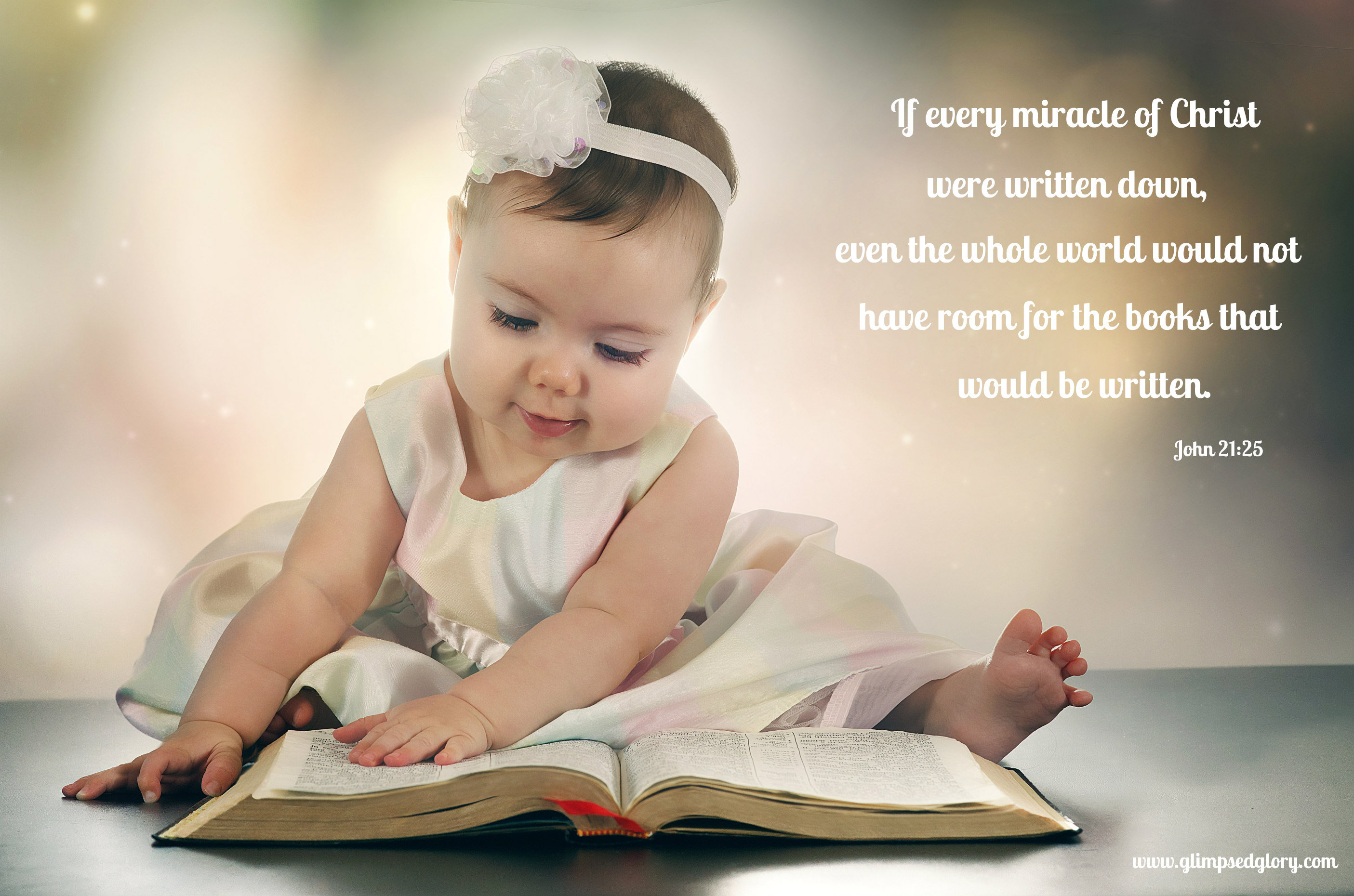 A young baby girl reads a Bible.
